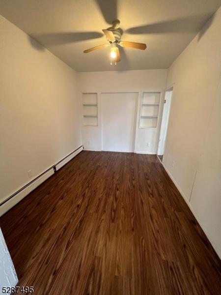 unfurnished bedroom featuring ceiling fan, hardwood / wood-style floors, and a baseboard radiator