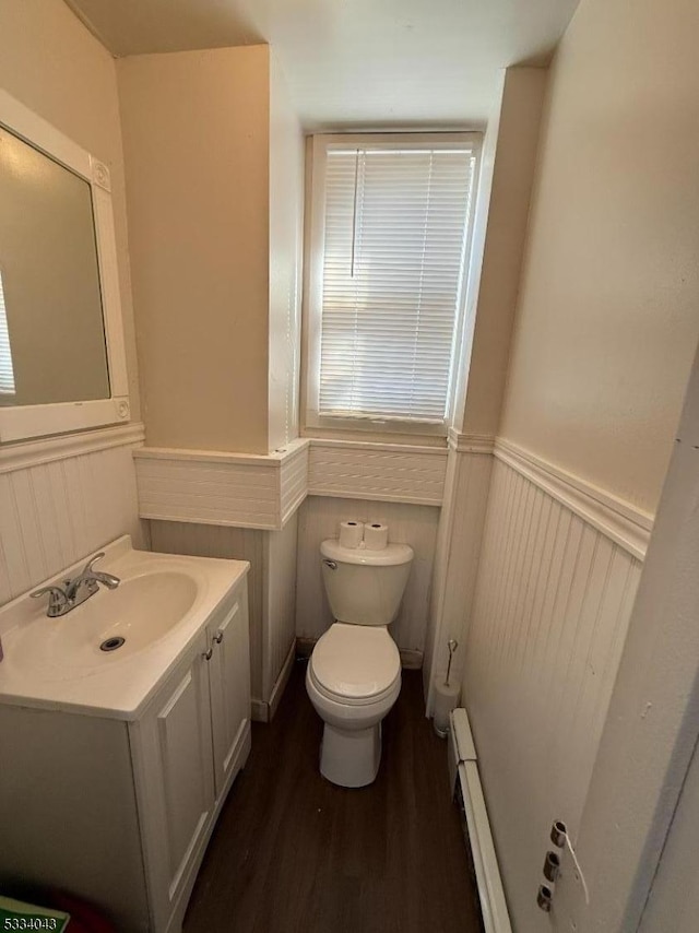 bathroom with hardwood / wood-style floors, toilet, a baseboard heating unit, and vanity