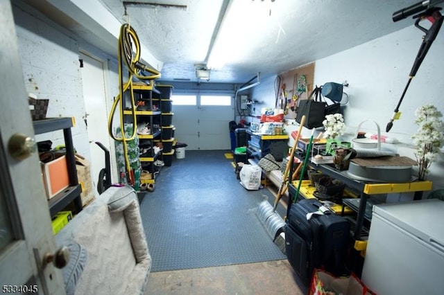 garage with a garage door opener, refrigerator, and a workshop area