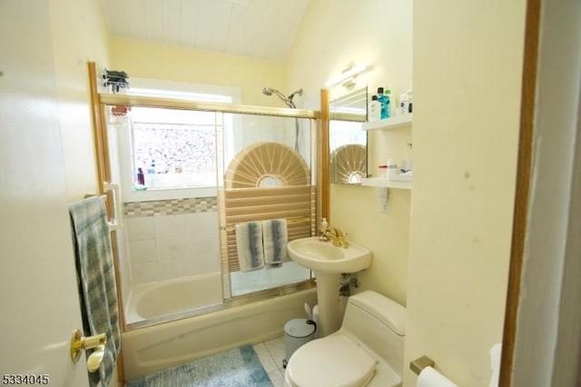 bathroom with vaulted ceiling, tile patterned floors, toilet, and combined bath / shower with glass door