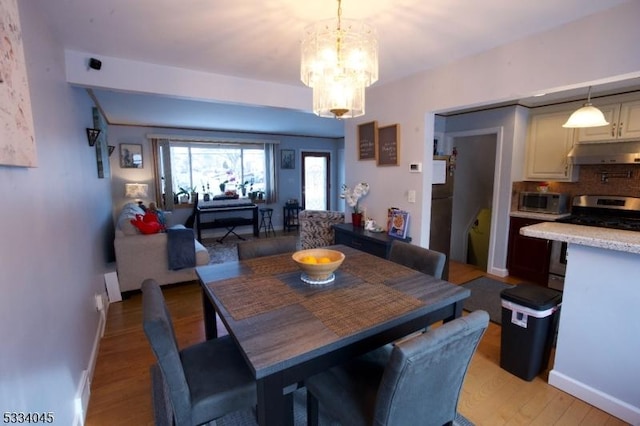 dining area with a chandelier and light wood-type flooring