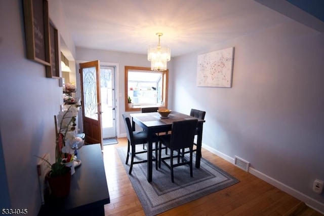 dining room with a chandelier and light hardwood / wood-style floors