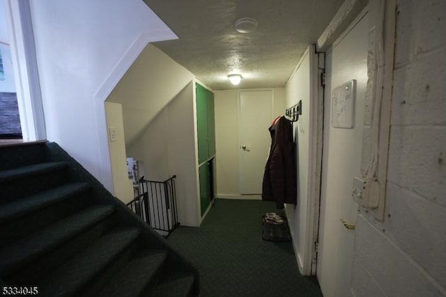 hallway with carpet floors and a textured ceiling