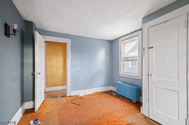 carpeted empty room with radiator heating unit