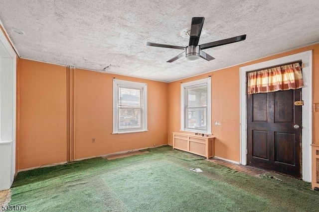 carpeted empty room featuring a textured ceiling and ceiling fan