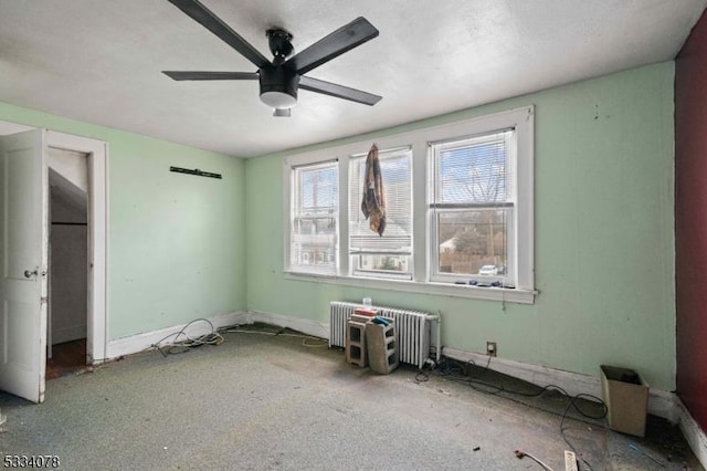 unfurnished room featuring ceiling fan and radiator heating unit