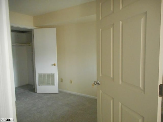 unfurnished bedroom featuring a closet and light carpet