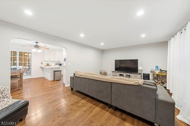 living room with ceiling fan and light hardwood / wood-style flooring