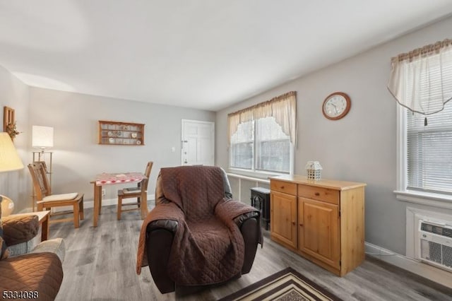 sitting room featuring a wall mounted AC and light hardwood / wood-style flooring