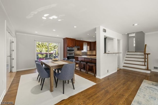 dining space with crown molding and dark hardwood / wood-style flooring