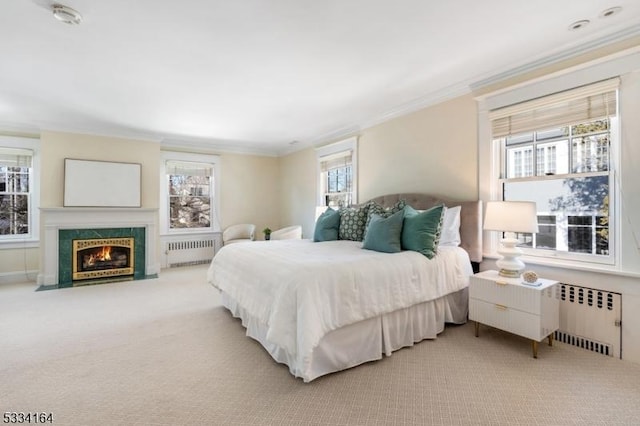 bedroom featuring ornamental molding, a high end fireplace, light carpet, and radiator heating unit