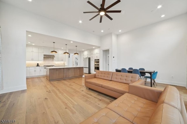 living room featuring ceiling fan and light hardwood / wood-style flooring