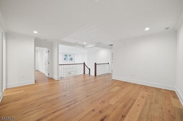 empty room featuring crown molding and light hardwood / wood-style floors