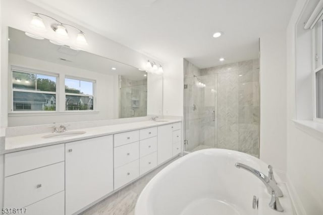 bathroom featuring vanity and shower with separate bathtub