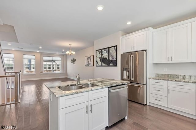 kitchen with sink, an island with sink, white cabinets, and appliances with stainless steel finishes