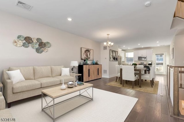 living room with an inviting chandelier and dark hardwood / wood-style flooring