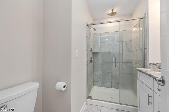 bathroom featuring vanity, a shower with shower door, and toilet