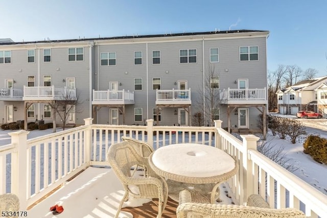 view of snow covered back of property