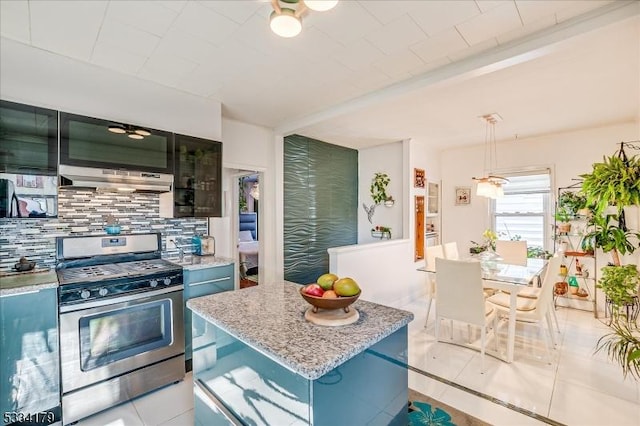 kitchen featuring a center island, under cabinet range hood, stainless steel range with gas cooktop, pendant lighting, and backsplash