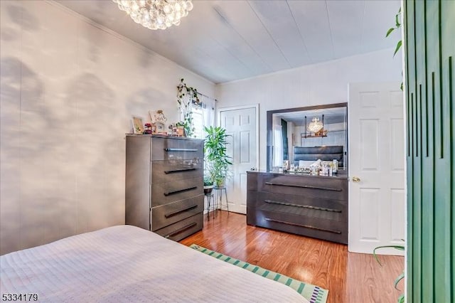 bedroom featuring an inviting chandelier and wood finished floors