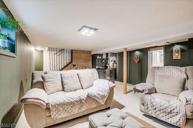 living area with wooden walls and stairway