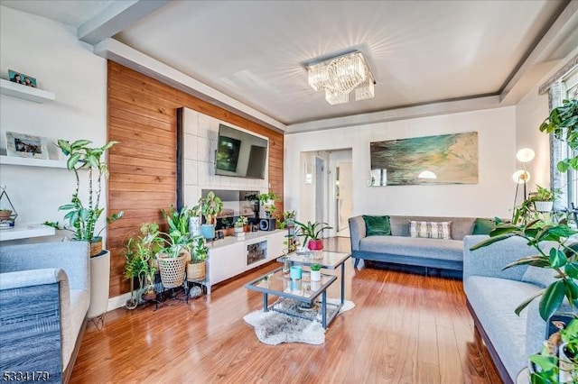 interior space with a notable chandelier, wood walls, and wood finished floors