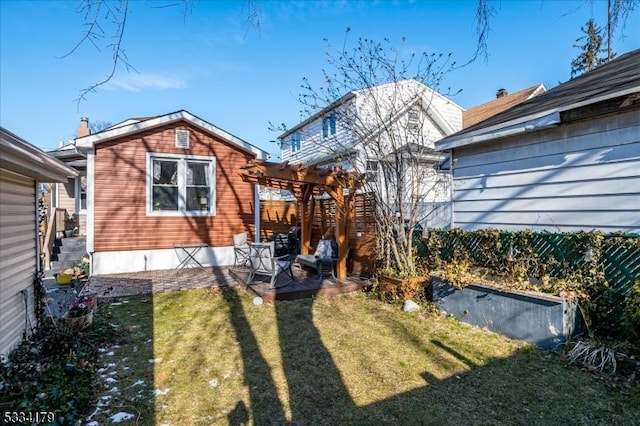 rear view of house featuring a yard and a pergola