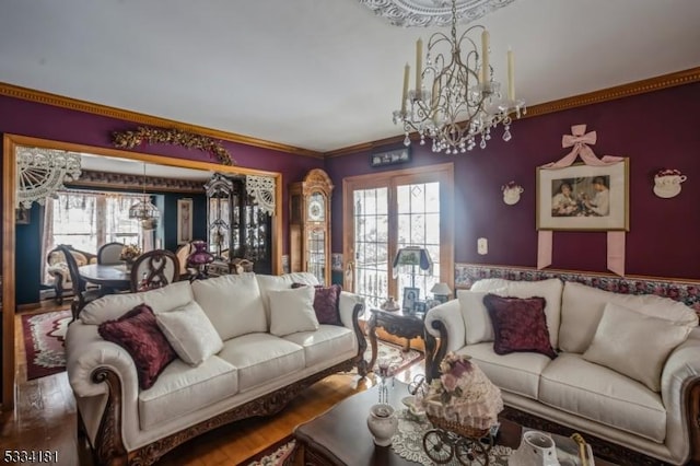 living room featuring an inviting chandelier, hardwood / wood-style floors, crown molding, and plenty of natural light