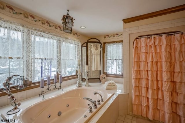 bathroom featuring a relaxing tiled tub and tile patterned flooring