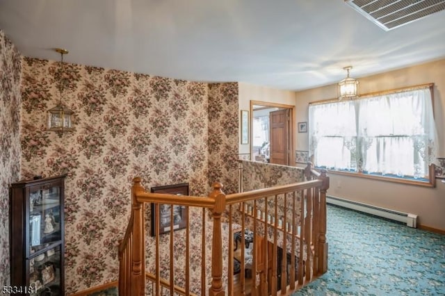 stairway featuring baseboard heating and carpet flooring