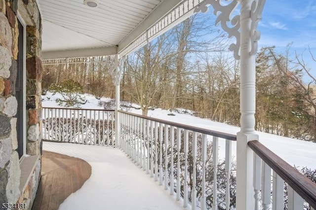 view of snow covered back of property