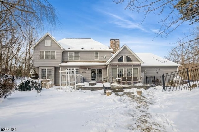 view of snow covered back of property