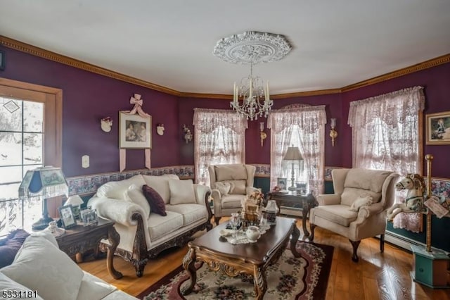 living room featuring an inviting chandelier, hardwood / wood-style flooring, and crown molding