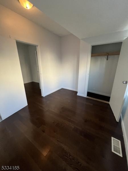 unfurnished room featuring dark hardwood / wood-style floors