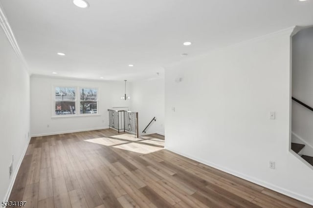 unfurnished living room with crown molding and light hardwood / wood-style floors