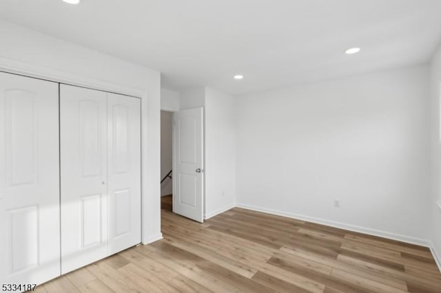 unfurnished bedroom featuring light hardwood / wood-style floors and a closet