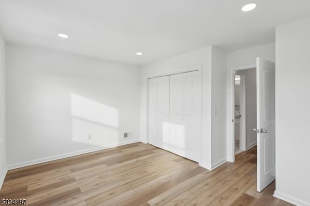 unfurnished bedroom with light hardwood / wood-style floors and a closet