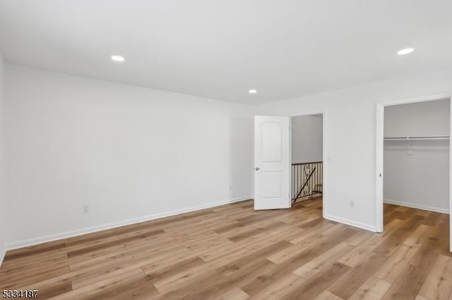 unfurnished bedroom with light hardwood / wood-style flooring and a closet