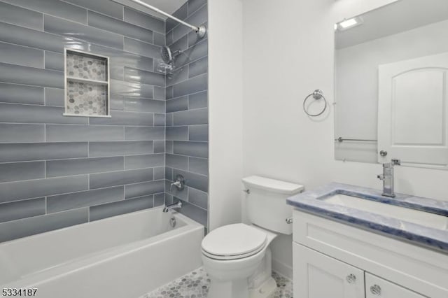 full bathroom featuring vanity, toilet, and tiled shower / bath