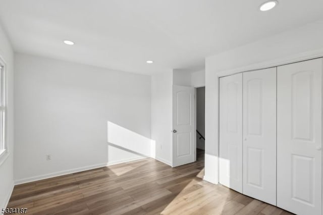 unfurnished bedroom featuring hardwood / wood-style floors and a closet