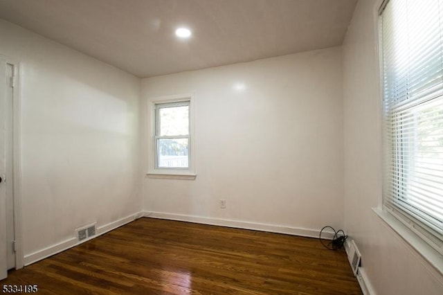 unfurnished room with dark wood-type flooring