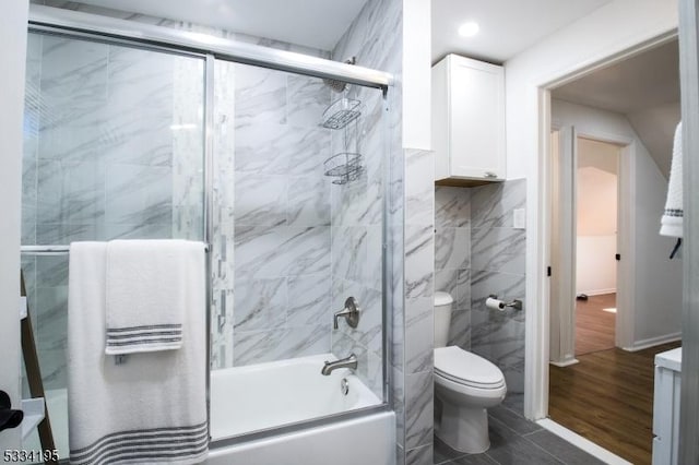 bathroom featuring enclosed tub / shower combo and toilet