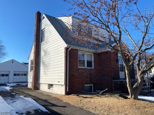 view of property exterior with a garage and an outbuilding