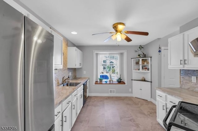 kitchen featuring stainless steel appliances, white cabinetry, sink, and decorative backsplash