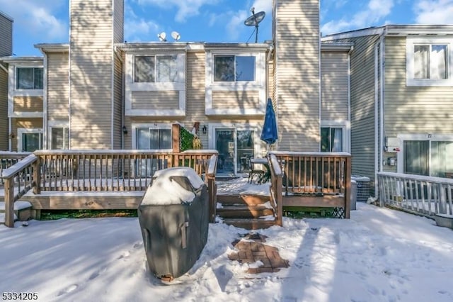 snow covered property with a wooden deck