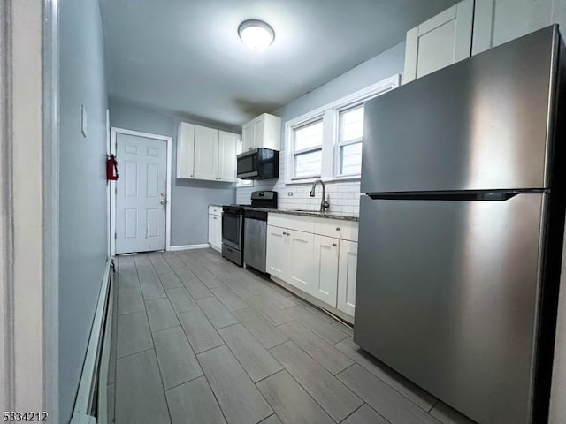 kitchen with stainless steel appliances, white cabinetry, sink, and a baseboard radiator