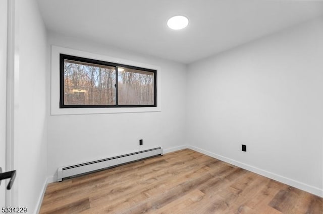 unfurnished room featuring a baseboard radiator and wood-type flooring