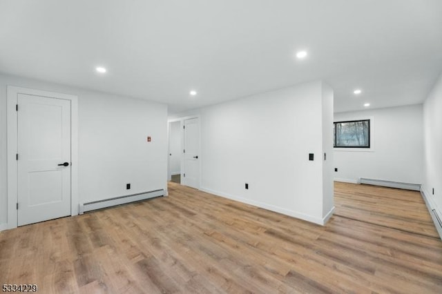 basement featuring light hardwood / wood-style flooring and a baseboard radiator