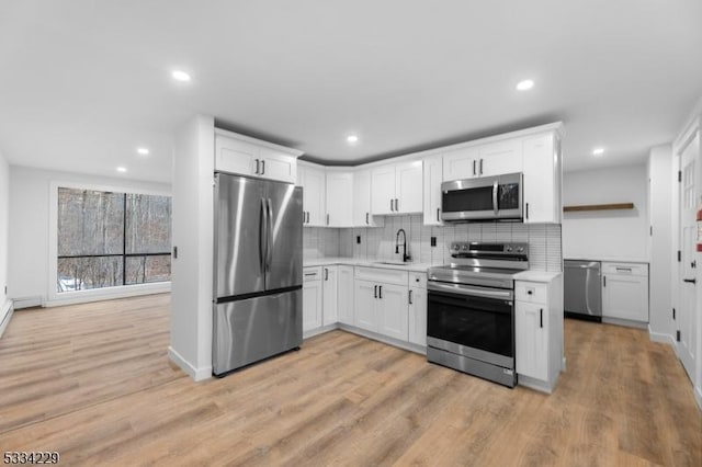 kitchen with sink, light hardwood / wood-style flooring, stainless steel appliances, and white cabinets