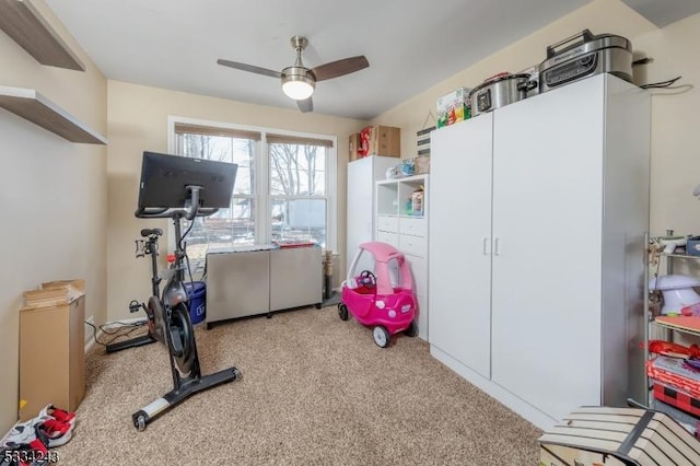 workout area with ceiling fan and light colored carpet